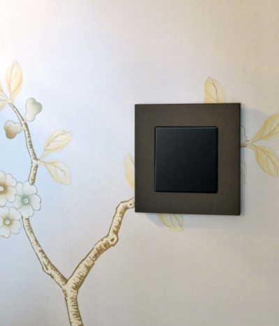 GIRA Esprit Dark Bronze light switch on patterned wall